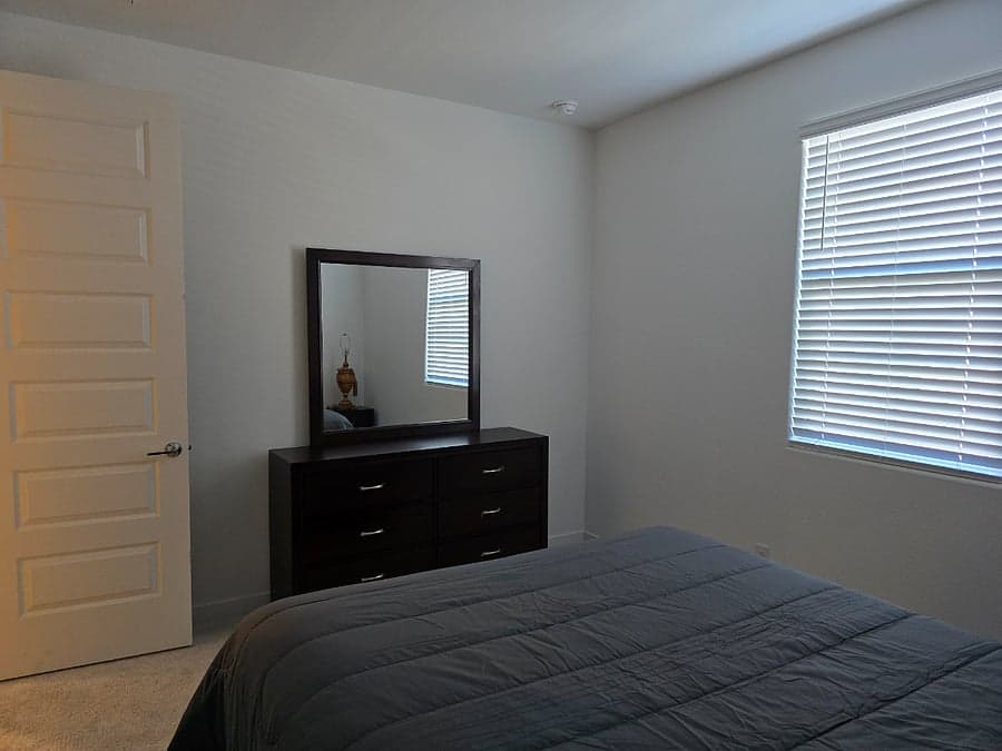 Bedroom with dresser, mirror, and natural light