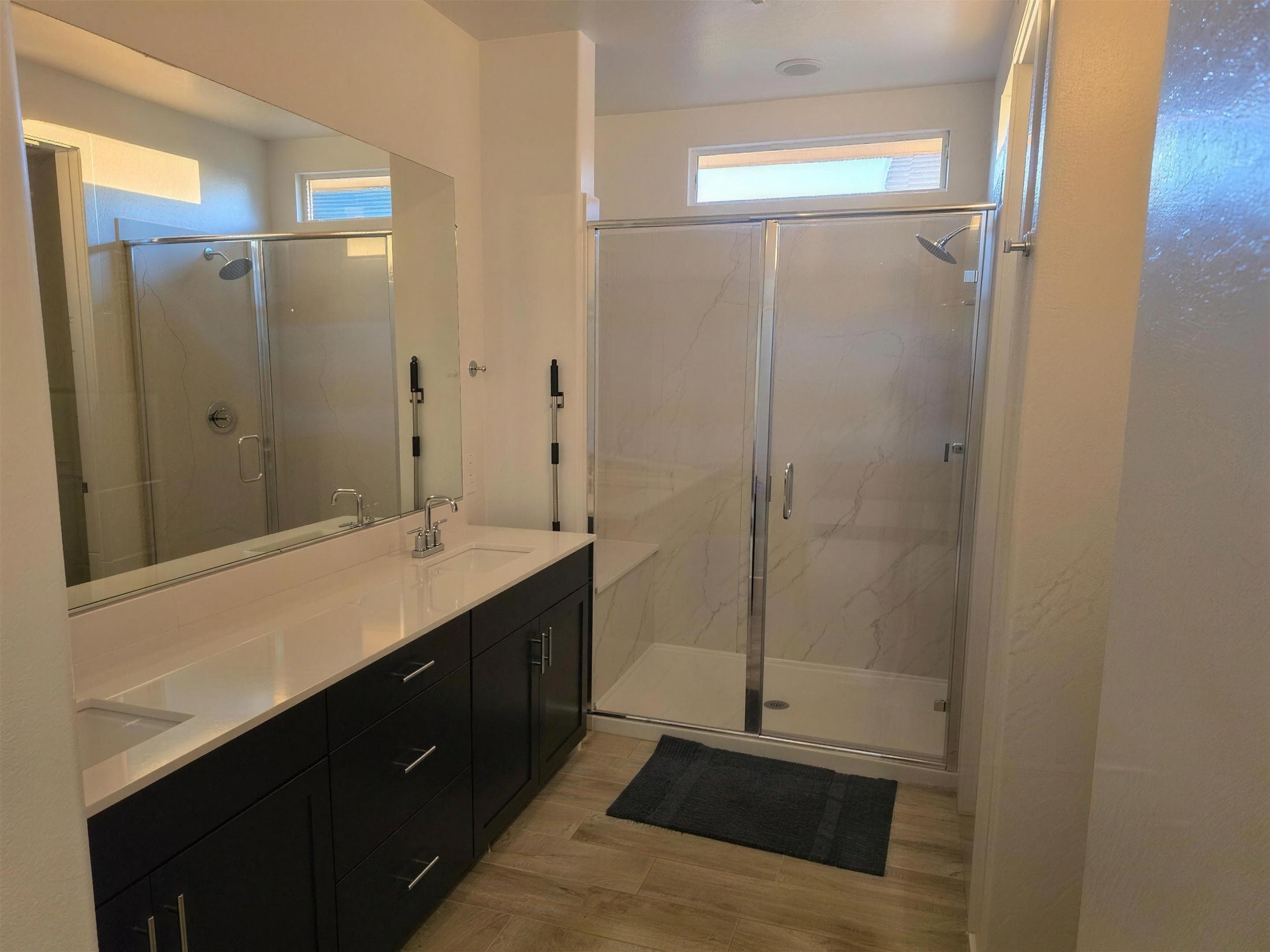 Primary bathroom with double vanity and glass walk-in shower